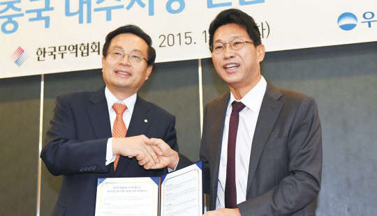 15일 서울 강남구 삼성동 트레이드타워에서 열린 '무협-우리은행, 중국 내수시장 진출 지원 협약식'에서 김정관 한국무역협회 상근부회장(오른쪽)과 손태승 우리은행 글로벌그룹장이 협약서를 들고 기념촬영을 하고 있다.   무역협회 제공